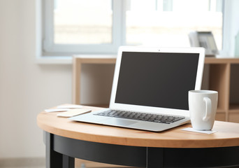 Stylish workplace with laptop on table