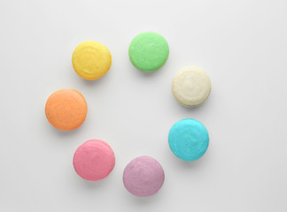 Tasty colorful macarons on white background, flat lay