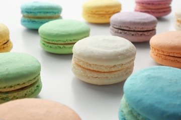 Tasty colorful macarons on white background, closeup