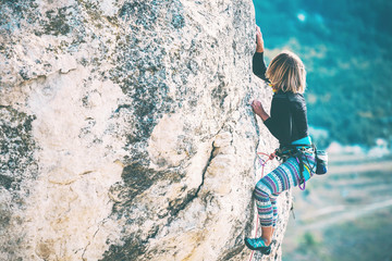 Girl climbs the rock.