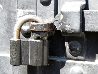 Old padlock on metal door. Rusty lock on a iron gate