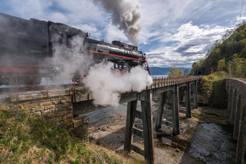 The old steam locomotive is driving along the bridge