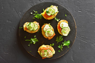 Toasted bread with salmon, scrambled eggs and cucumber
