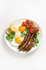 Fried eggs, sausages and cherry tomatoes