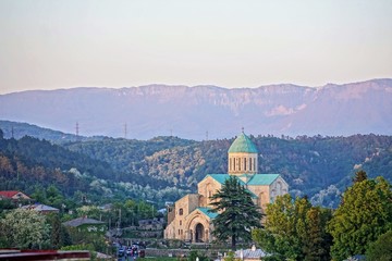 Fototapeta na wymiar Evening landscape with the building of the Kutaisi Cathedral (Bagrati Cathedral) in the foreground in Kutaisi, Georgia (Europe), Caucasus