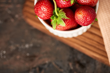 Fresh red strawberry on a dark abstract background. Summer berries. The concept of healthy eating.