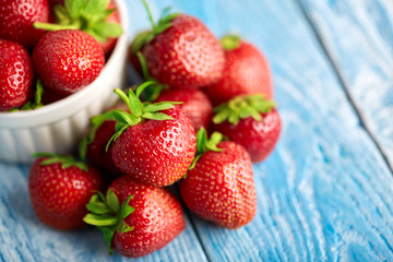 Fresh red strawberries on a blue wooden background. Summer berries. The concept of healthy eating.