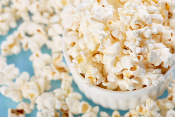 Popcorn on a bright blue background. Film. Fast food. Corn