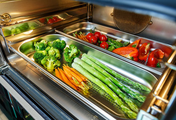 Vegetables on a baking tray prepared in a steam oven