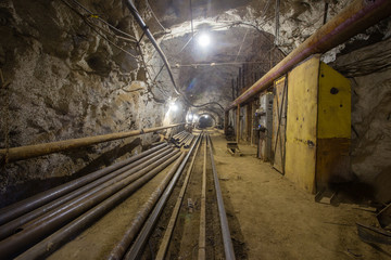 Fototapeta na wymiar Underground old ore gold mine tunnel shaft passage mining technology with rails