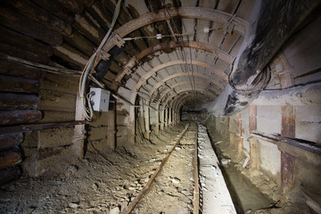 Fototapeta na wymiar Underground glod ore mine shaft tunnel gallery with timber and light