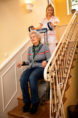 Fototapeta na wymiar Helps senior old disabled woman to climb the stairs with machine at nursing home