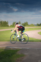 Fototapeta na wymiar Cyclist man riding road sport bike in sunny day on a mountain road