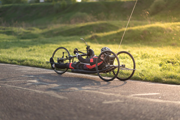 A close up of the handbike athlete on the special bicycle asphalt track in Krylatskie Hills. Evening sunset above the road. - 208406134