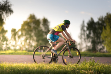 Cyclist man riding road sport bike in sunny day on a mountain road