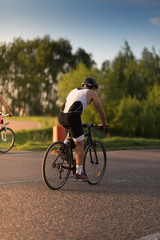 Fototapeta premium Cyclist man riding road sport bike in sunny day on a mountain road