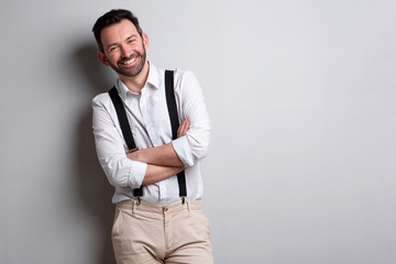 happy man with beard posing against gray wall