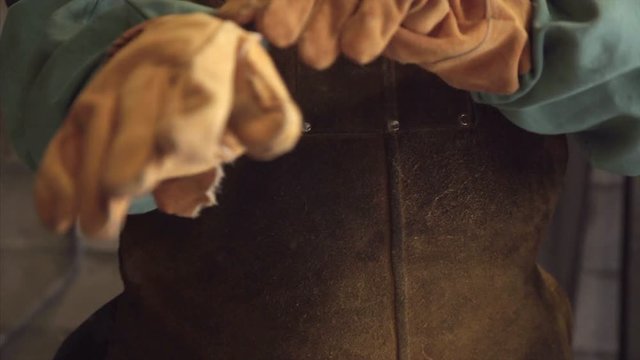 Professional welder puts on gloves