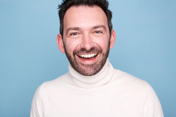 Obraz premium Close up older man with beard laughing against blue background