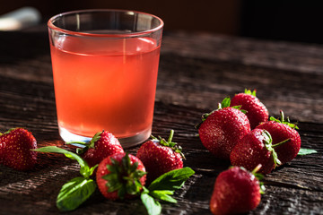Fresh strawberries ang strawberry juice on wood
