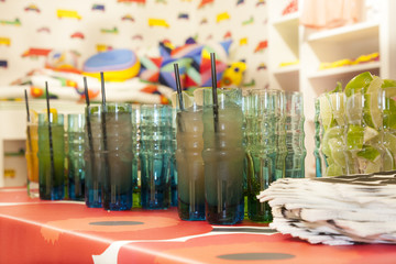 Refreshing cocktails in designer glasses on a bar in a colorful shop waiting for party guests.