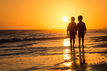 silhouette of boys by the ocean