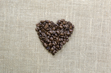 corazón de granos de cafe sobre arpillera