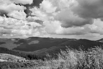 black and white mountain landscape in summer with a cloudy sky