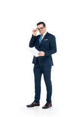 full length view of businessman in eyeglasses holding digital tablet and looking at camera isolated on white