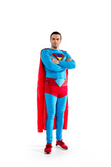 full length view of confident handsome superman standing with crossed arms and looking at camera...