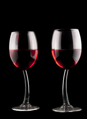 two glasses of red wine on a black background 