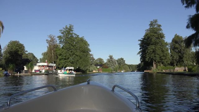 Ruderboot mit Elektro Antrieb fährt langsam durch einen Fluss bzw. Kanal.