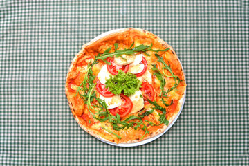 Tasty pizza on a tablecloth in a cage