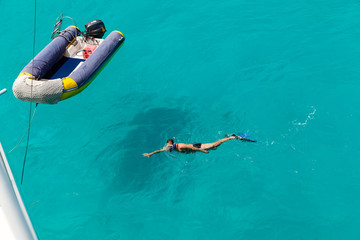 Inflatable rubber boats and sunbathers in the crystal-clear turquoise water