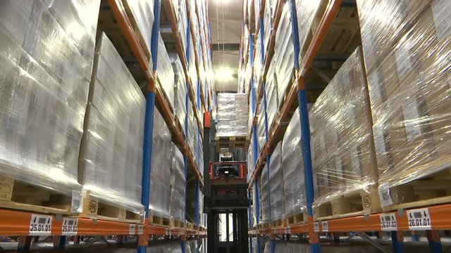 Forklift in a warehouse. Modern forklift going up