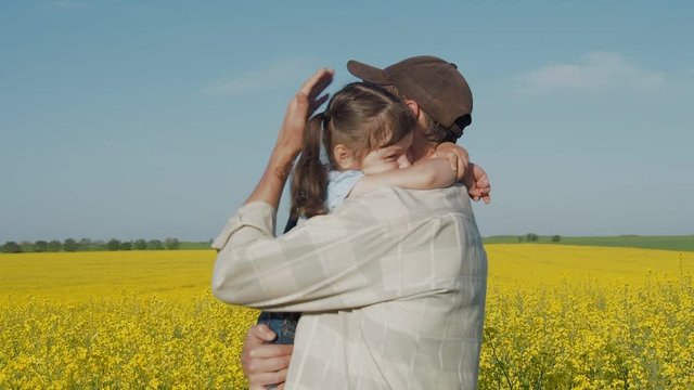 The daughter hugs father. Happy family in nature. A farmer with a child in the field.