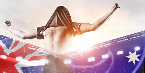 Australia national team. Double exposure photo of stadium and soccer or football player celebrating goal with his jersey on head