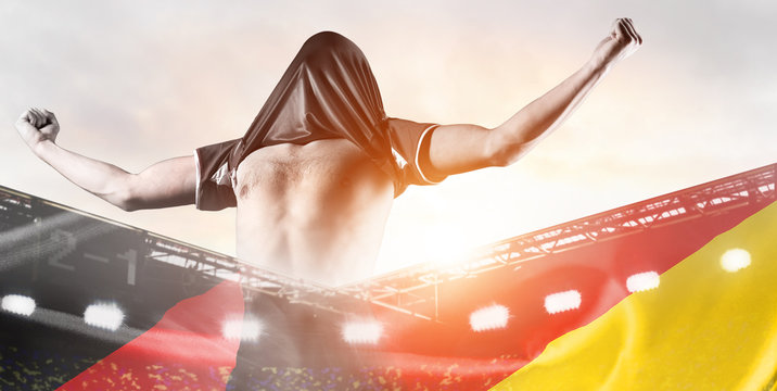 Germany national team. Double exposure photo of stadium and soccer or football player celebrating goal with his jersey on head