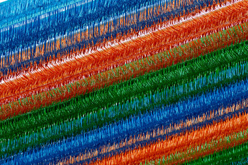Bright decorative covering of blue, red, orange and green strips. It is made of long plastic strips...
