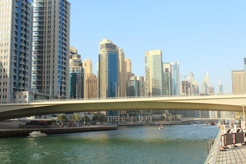 Fototapeta na wymiar United Arab Emirates. Dubai Marina Canal. Skyscrapers in Dubai. Reinforced concrete road bridge through the canal. Landscape. Background. Spring, March, 2018.