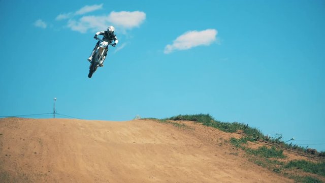 Driver of a motorcycle is performing a jumping trick