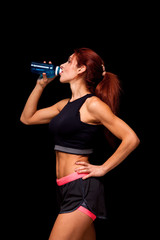 beautiful woman with bottle of water. Perfect female body isolated on black background