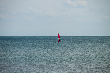 Windsurfing. Surfer exercising in calm sea or ocean.