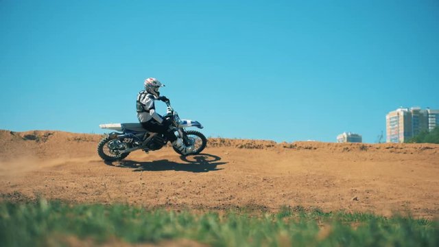Professional motorcycler is driving across sandy terrain