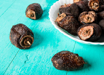 Dried persimmon - healthy raw dessert in a plate on a blue wooden background