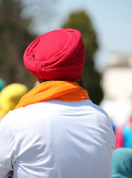 Sikh man with a fuchsia turban and an orange scarf