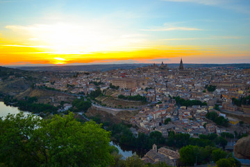 Fototapeta premium Sunset at lookout of Toledo, Spain. Tajo river around the city and Alcazar and Cathedral at background. 