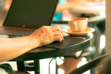Business hand typing on laptop keyboard with hot coffee cup on desk