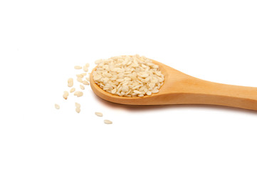 white sesame seeds in wooden spoon isolated on the white
