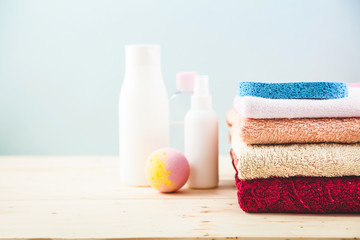 Obraz na płótnie Canvas bathroom accessories - towels, cream, bath foam and shampoos on a light, bright background Concept of caring for yourself, your body Place for copy space